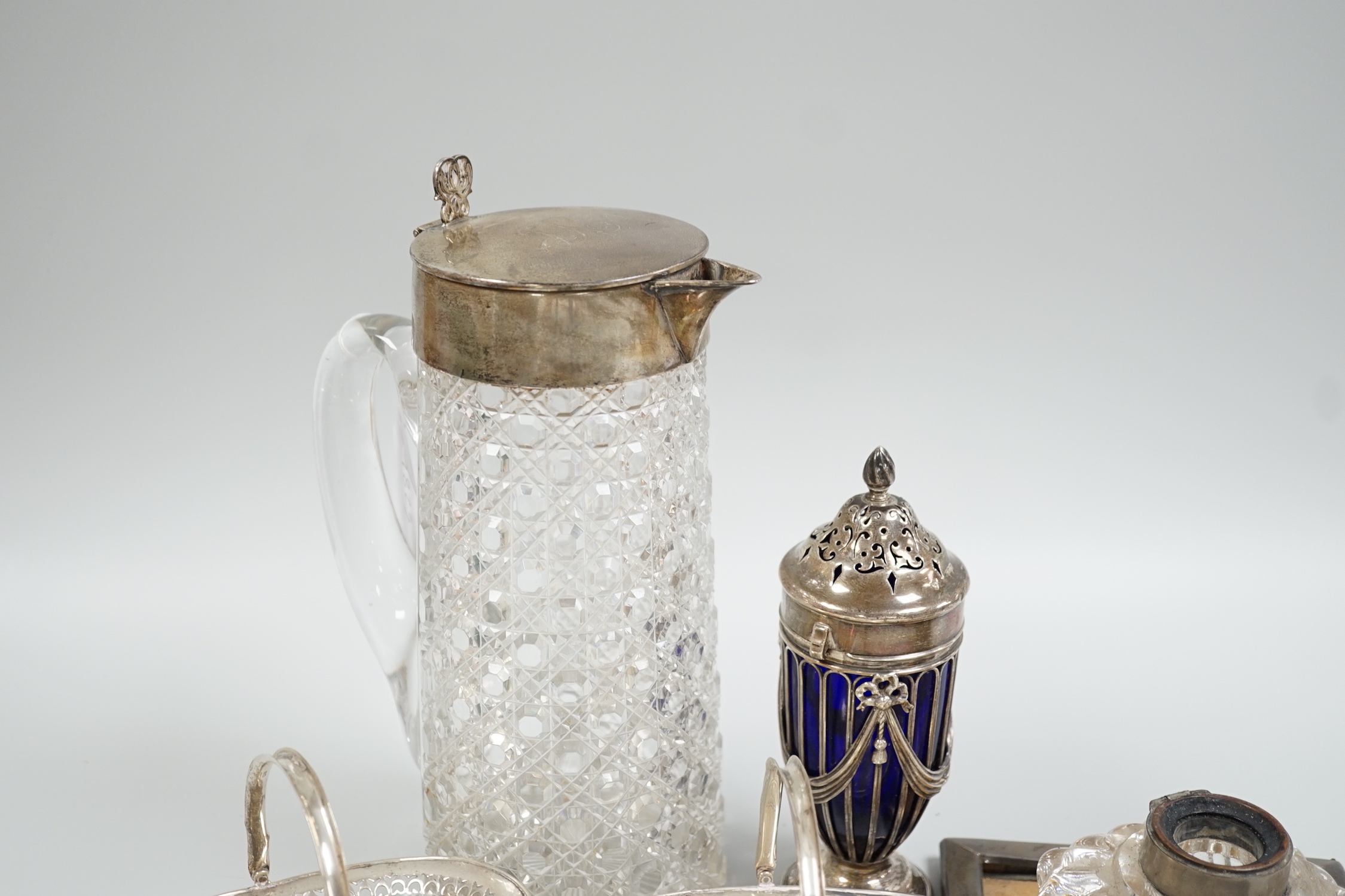 Sundry silver items including a Victorian silver mounted glass lemonade jug (a.f.), mounted glass sugar caster, damaged inkwell, photograph frame, pair of silver bonbon baskets and a small silver dish.